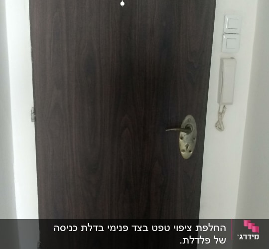 דלת עץ כהה עם ידית מתכת